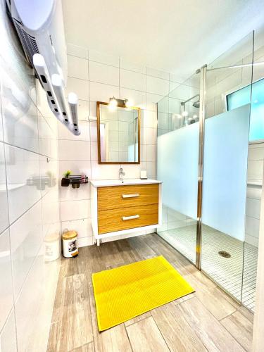 La salle de bains est pourvue d'une douche et d'un tapis jaune. dans l'établissement Chez Coccinelle, à Marmagne