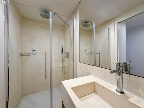 a white bathroom with a shower and a sink at Bellechasse Apartments in Paris