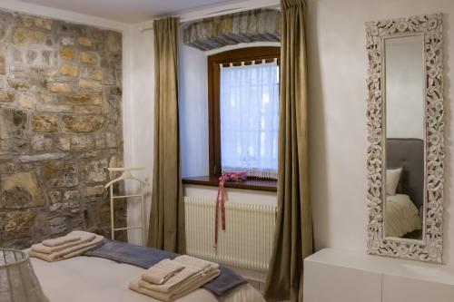 a bedroom with a stone wall and a mirror at Collio Suite in Cormòns