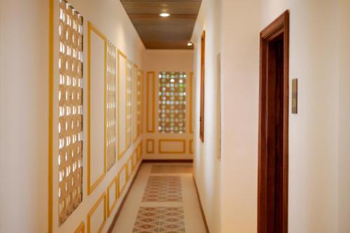 a hallway with yellow walls and a tile floor at Fourteen Roses Boutique Hotel, Kuta in Legian