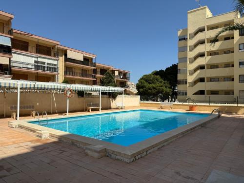 an empty swimming pool in front of a building at Casa en la playa de los Arenales in Arenales del Sol