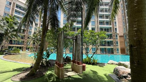 ein Resort mit Swimmingpool und Palmen in der Unterkunft Atlantis Condo Resort Pattaya in Jomtien Beach