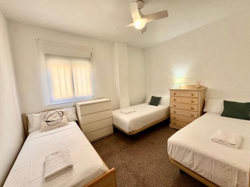 a small bedroom with two beds and a window at Casa en la playa de los Arenales in Arenales del Sol