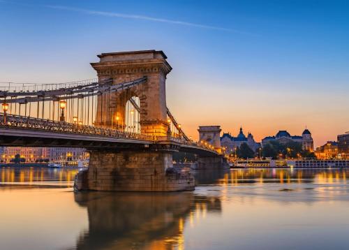 a bridge over a river with a city in the background at Verdi Budapest Aquincum in Budapest