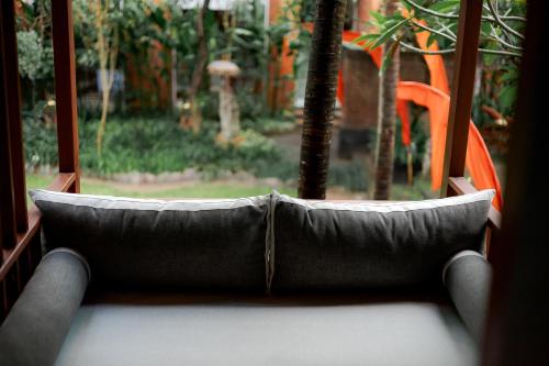 a couch sitting in front of a window at Fourteen Roses Boutique Hotel, Kuta in Legian