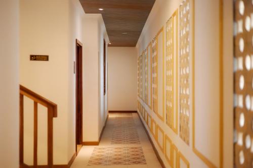 a hallway with white walls and a tile floor at Fourteen Roses Boutique Hotel, Kuta in Legian