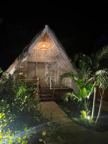 a small wooden house with a porch at night at Living Trawangan Hotel in Gili Trawangan