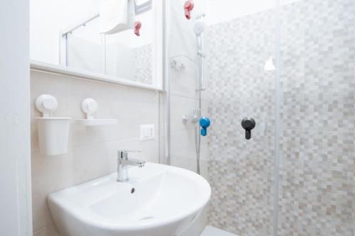 Un baño blanco con lavabo y ducha en BeachFront Villa, en Bari