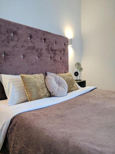 a bedroom with a large bed with a purple headboard at Best One Room Apartments in Mukacheve