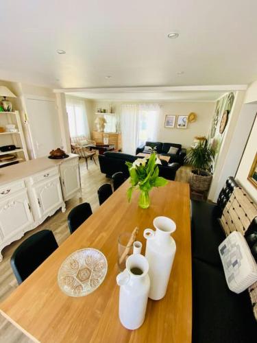 une table en bois avec deux vases dessus dans un salon dans l'établissement Maison à 50 m de la plage, au Croisic