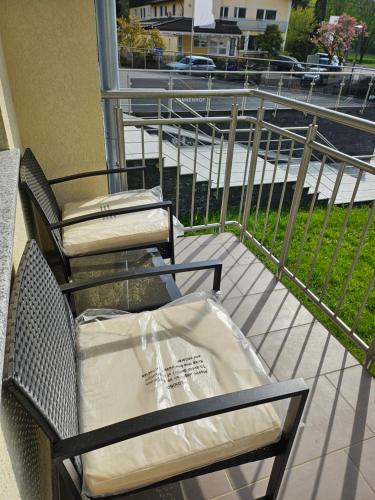two chairs sitting on a balcony with a bag on them at Hotel Sonnenhof in Bad Waldsee