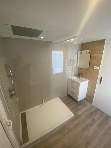 une salle de bain avec une baignoire blanche et un lavabo dans l'établissement Maison à 50 m de la plage, au Croisic