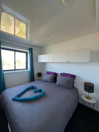 - un lit avec un ruban bleu au-dessus dans l'établissement JOIA Bassin d'Arcachon - LE ROOF 269, à La Teste-de-Buch