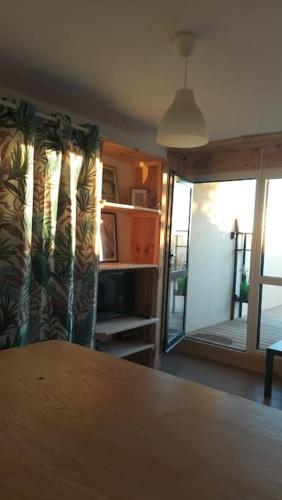 d'un salon avec une table et une porte coulissante en verre. dans l'établissement Le Petit BoiSoleil, à Lacanau