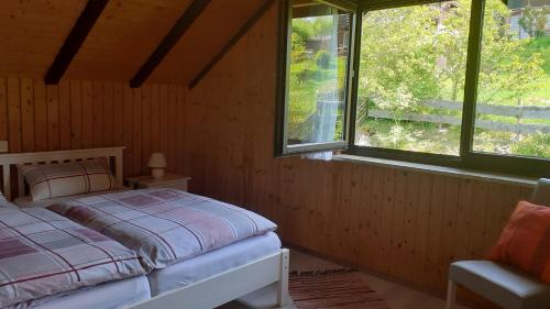 a bedroom with a bed and two windows at Ferienhaus Talblick in Fladungen