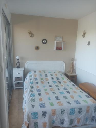 une chambre avec un lit avec une couette dessus dans l'établissement Joli studio avec piscine à 200m de la plage parking privé, à La Grande Motte