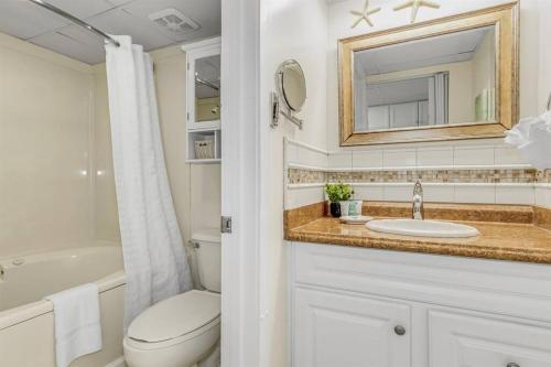 a bathroom with a toilet and a sink and a mirror at WINTER RATES! Ready Set and Relax, Oceanfront Suite w Jetted tub! B 1134 in Myrtle Beach