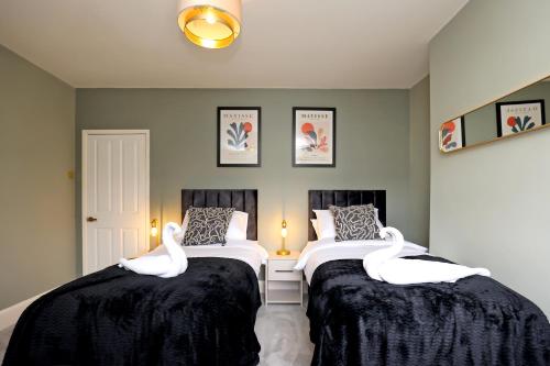 two swans sitting on two beds in a room at Elmbank House in New Ferry