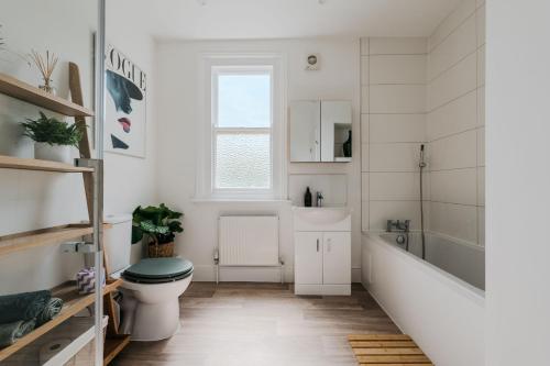 a bathroom with a toilet and a tub and a sink at The Lynton Lookout in Margate
