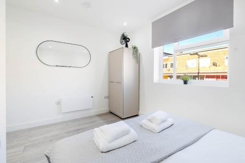 ein weißes Zimmer mit zwei weißen Kissen auf einem Bett in der Unterkunft Corby Town Centre Serviced Apartments in Corby