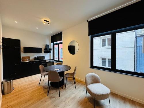 a living room with a table and chairs and a kitchen at Urbanchic Opéra 2B in Liège