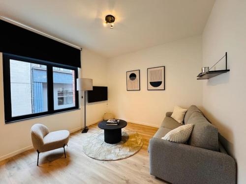 a living room with a couch and a table at Urbanchic Opéra 2B in Liège