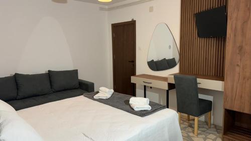 a bedroom with a bed and a desk with a couch at R&B Apartments in Budva