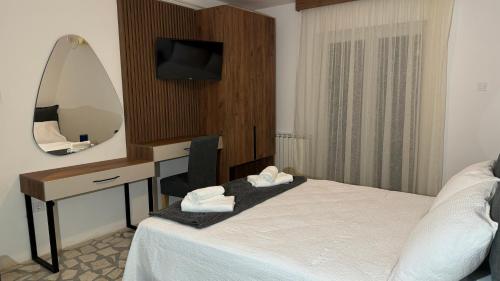 a hotel room with a bed and a desk with a mirror at R&B Apartments in Budva
