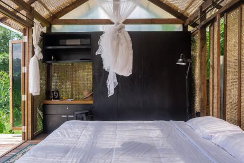 a bedroom with a large bed with a black wall at Calidas Hill in Kintamani