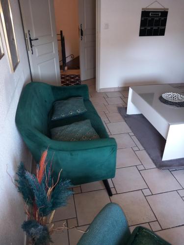 un salon avec une chaise verte et une table dans l'établissement Cosy de Vias, à Vias