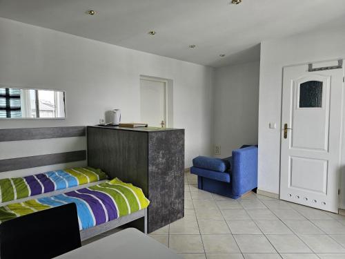 a bedroom with a bed and a blue chair at Pokoje u Marii in Międzyzdroje