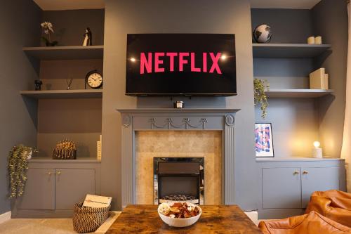a living room with a television above a fireplace at Elmbank House in New Ferry
