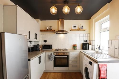 a kitchen with a refrigerator and a stove top oven at Elmbank House in New Ferry