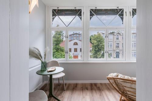 a room with windows and a table and chairs at Lapwing Nest in Sopot