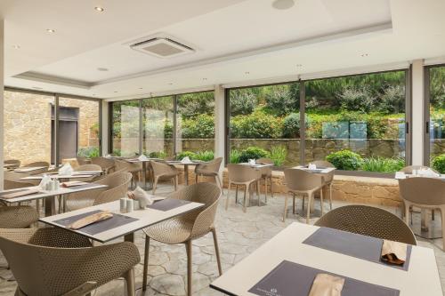a restaurant with tables and chairs and windows at Diamond Star Hotel in Falasarna