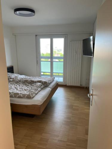 バーゼルにあるWohnung Basel City bis max 6 Personenのベッドと大きな窓のある寝室