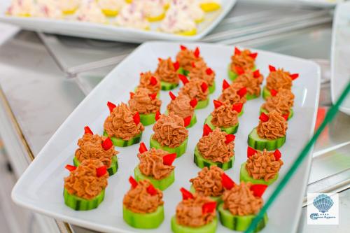 a white plate with green cupcakes with food on it at Hotel Carmen Azzuro in Venus