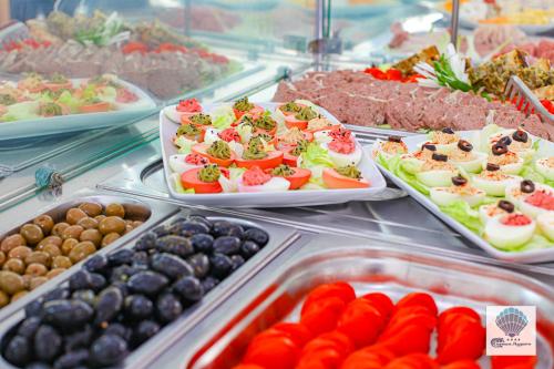 a buffet filled with different types of food in trays at Hotel Carmen Azzuro in Venus