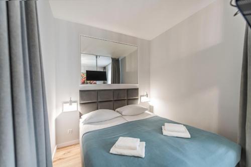 a bedroom with a bed with two towels on it at Lapwing Nest in Sopot