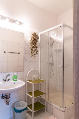 a bathroom with a shower and a sink at Magdalena Apartmanház in Keszthely