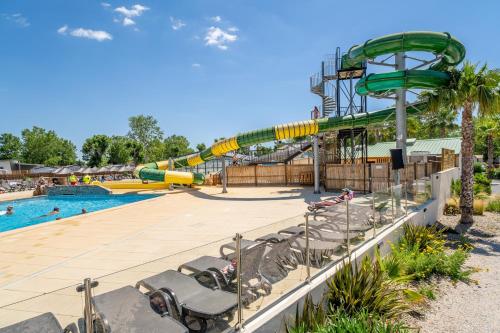 un parc aquatique avec un toboggan et une piscine dans l'établissement Charmant Mobil Home 6 personnes, à Vendres