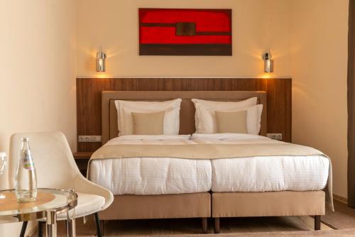 a bedroom with a large bed and a table at PENSIUNEA GAMBRINUS **** in Miercurea-Ciuc