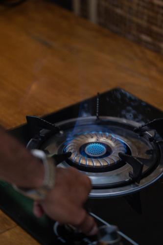 a person holding the handle of a stove at Calidas Hill in Kintamani