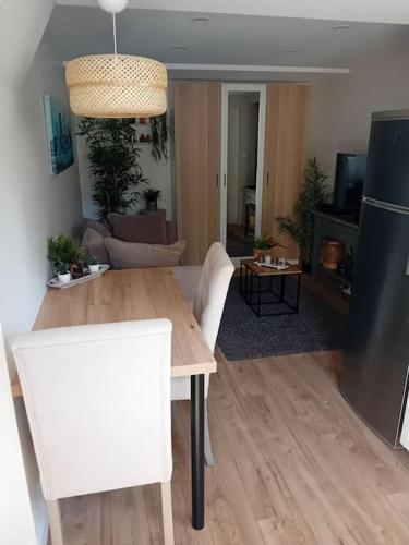 - un salon avec une table en bois et un canapé dans l'établissement Le Cocon Cosy proche gare, à Sainte-Geneviève-des-Bois