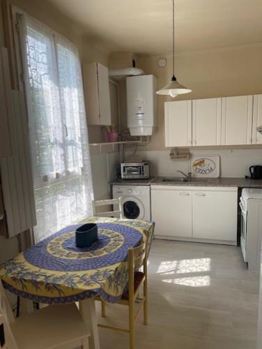 - une cuisine avec une table et un chapeau dans l'établissement Charmant T2 bucolique, à Trappes