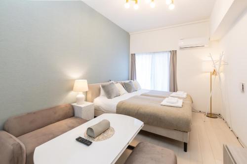 a living room with two beds and a couch at Primavera Namba Minami in Osaka