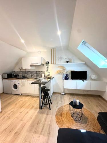 - une grande cuisine blanche avec une table dans une pièce dans l'établissement Charmant studio hyper centre, à Rodez