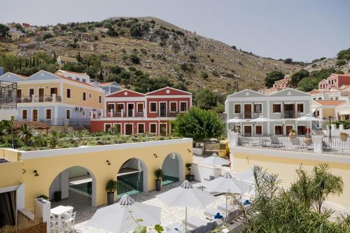 a view of a town with houses and umbrellas at Opera House Hotel in Symi