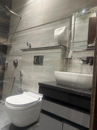 a bathroom with a white toilet and a sink at Ginger Garlic Chandigarh in Sohāna