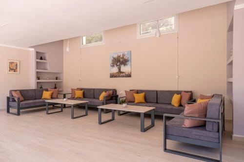 a living room with couches and tables at Tolo Villa Natura with Pool for 8 - private, luxury accommodation in Tolo
